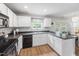 Kitchen with white cabinets, black countertops, a window, and a door to the outside at 5512 Bridgeman Ct, Durham, NC 27703