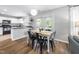 Eat-in kitchen with white cabinets, black appliances, and a view to the backyard at 5512 Bridgeman Ct, Durham, NC 27703