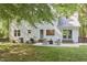 Back exterior with patio seating area and lush backyard with trees at 5642 Falkirk Dr, Durham, NC 27712