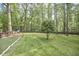 Expansive backyard with a swing set and lush green trees at 5642 Falkirk Dr, Durham, NC 27712