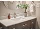 Close-up of bathroom vanity with wood cabinets, a white countertop, modern faucet, and decorative accents at 5642 Falkirk Dr, Durham, NC 27712