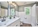 Well-lit bathroom features a double vanity, wood-look floors, and a tub/shower combo at 5642 Falkirk Dr, Durham, NC 27712