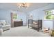 This light blue Bedroom is decorated with a crib, rocking chair, and dresser at 5642 Falkirk Dr, Durham, NC 27712