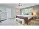 Cozy bedroom features a wooden bed frame, carpet flooring, and accent furniture at 5642 Falkirk Dr, Durham, NC 27712