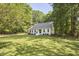 Charming white home with a well-manicured lawn and mature trees surrounding the property at 5642 Falkirk Dr, Durham, NC 27712