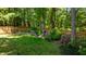 Landscaped backyard featuring a well-maintained lawn, vibrant rhododendrons, and a charming wooden fence bordering the property at 624 Moultonboro Ave, Wake Forest, NC 27587