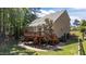 Spacious backyard featuring a wooden deck, brick patio, and lush landscaping at 624 Moultonboro Ave, Wake Forest, NC 27587