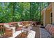 The wooden deck has comfortable wicker furniture creating a tranquil space surrounded by lush trees at 624 Moultonboro Ave, Wake Forest, NC 27587
