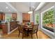 Bright dining area with hardwood floors, a round table, and large windows overlooking the lush greenery at 624 Moultonboro Ave, Wake Forest, NC 27587