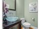 Stylish powder room with a unique glass vessel sink and decorative mirror at 624 Moultonboro Ave, Wake Forest, NC 27587