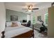 Bedroom with a wooden bed frame, desk, ceiling fan, and workout equipment by the window at 6324 Daybreak Dr, Wake Forest, NC 27587