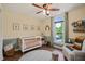 Bedroom features a white crib, chair, large window, neutral tones and animal-themed decor at 6324 Daybreak Dr, Wake Forest, NC 27587