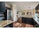 Open kitchen with dark cabinets, granite countertops, and stainless steel refrigerator at 6324 Daybreak Dr, Wake Forest, NC 27587