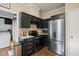 Well-lit kitchen with black cabinets, granite countertops, and stainless steel appliances at 6324 Daybreak Dr, Wake Forest, NC 27587