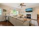 Sunlit living room features a cozy fireplace, large windows, hardwood floors, and a comfortable sectional at 6324 Daybreak Dr, Wake Forest, NC 27587