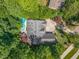 Aerial view of home surrounded by lush trees and landscaping and a beautiful in-ground pool at 6509 Mountain Brook Ln, Raleigh, NC 27615