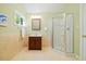 Bathroom with light yellow tile, updated sink and vanity, glass enclosed shower and framed mirror at 6509 Mountain Brook Ln, Raleigh, NC 27615
