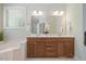 Bathroom features a double vanity, a large mirror with decorative lighting, and tiled floors at 6509 Mountain Brook Ln, Raleigh, NC 27615