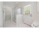 Bathroom featuring glass shower stall and door to outside and white tile flooring at 6509 Mountain Brook Ln, Raleigh, NC 27615