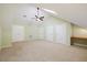 Large bedroom with light green walls, carpet flooring, ceiling fan and multiple doors at 6509 Mountain Brook Ln, Raleigh, NC 27615