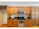 Kitchen featuring stainless steel appliances, granite counters, and wooden cabinets at 6509 Mountain Brook Ln, Raleigh, NC 27615