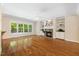 Inviting living room with a stone fireplace, hardwood floors, and large windows overlooking the yard at 6509 Mountain Brook Ln, Raleigh, NC 27615