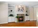 Cozy living room featuring a stone fireplace and built-in bookshelves with hardwood floors at 6509 Mountain Brook Ln, Raleigh, NC 27615