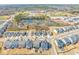Community aerial view featuring modern homes, a picturesque pond, and a school with athletic fields at 6633 Penfield St, Wake Forest, NC 27587