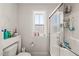 Updated bathroom featuring a shower with glass doors, tiled floors, and a window with privacy glass at 6633 Penfield St, Wake Forest, NC 27587