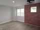 Bright bedroom with a brick accent wall, large windows, and modern vinyl flooring at 6633 Penfield St, Wake Forest, NC 27587
