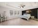 Well-lit bedroom with modern ceiling fan, tray ceiling, and a decorative accent wall at 6633 Penfield St, Wake Forest, NC 27587