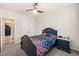 Cozy bedroom featuring carpet, ceiling fan, floral bedding, and natural light at 6633 Penfield St, Wake Forest, NC 27587