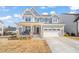 Charming two-story home with a welcoming front porch, beautiful stone accents, and a well-manicured lawn at 6633 Penfield St, Wake Forest, NC 27587