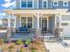 Inviting front porch with a cozy swing, stone pillars, decorative plants, and a charming entrance at 6633 Penfield St, Wake Forest, NC 27587