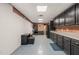 Spacious kitchen with grey countertops, brick wall and black cabinets at 6633 Penfield St, Wake Forest, NC 27587