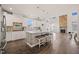 Open-concept kitchen featuring white cabinets, a large island with seating, and a view of the fireplace at 6633 Penfield St, Wake Forest, NC 27587