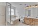 Bright bathroom featuring a walk-in shower, tub, and a double vanity with lighting at 7 Bonham Ct, Durham, NC 27703