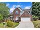 Charming two-story brick home featuring an attached two-car garage and beautifully landscaped front yard at 7 Bonham Ct, Durham, NC 27703