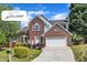 Charming two-story brick home featuring a well-manicured lawn, attached garage, and inviting front porch at 7 Bonham Ct, Durham, NC 27703