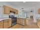 Open kitchen with hardwood floors, light wood cabinets, an island and view to an adjoining living room at 7 Bonham Ct, Durham, NC 27703