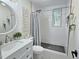 Updated bathroom with white vanity, round mirror, and tiled walk-in shower at 707 Wade Ave, Raleigh, NC 27605