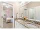 Granite counters and double sinks highlight this bathroom, with a view to an adjacent bedroom at 712 Evanvale Ct, Cary, NC 27518