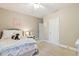 Cozy bedroom with neutral walls, plush carpet, ceiling fan, and unique decorative touches at 712 Evanvale Ct, Cary, NC 27518