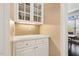 Convenient butler's pantry features a countertop, glass-front cabinets and serves as a seamless transition to dining area at 712 Evanvale Ct, Cary, NC 27518