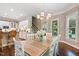 Open dining area has views to kitchen and stairway with an attractive light fixture and natural light at 712 Evanvale Ct, Cary, NC 27518