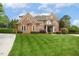 Elegant brick home features lush lawn and beautiful landscaping, creating curb appeal at 712 Evanvale Ct, Cary, NC 27518