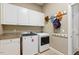 Spacious laundry room with modern washer and dryer, cabinet storage, and convenient wall hooks at 712 Evanvale Ct, Cary, NC 27518