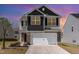 Charming two-story home with a stone and gray exterior, complemented by a well-manicured front yard and a spacious two-car garage at 729 Little Patch St, Zebulon, NC 27597