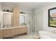Elegant bathroom featuring dual vanities, a soaking tub, and a glass-enclosed shower at 7401 Ray Rd, Raleigh, NC 27613