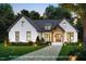 Charming white brick home with a welcoming front entrance and a well-manicured lawn at 7401 Ray Rd, Raleigh, NC 27613